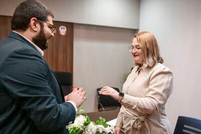 Itamar Bareket, from Tel Aviv, places the ring on to his wife-to-be Nogah's finger at the civil court in Abu Dhabi. Khushnum Bhandari / The National