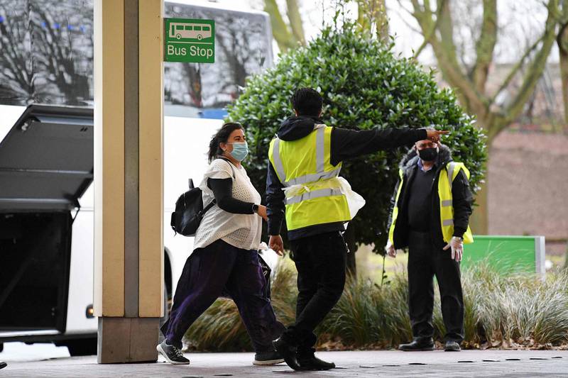 A traveller arrives by coach and is escorted by staff into the Holiday Inn hotel near Heathrow Airport. AFP