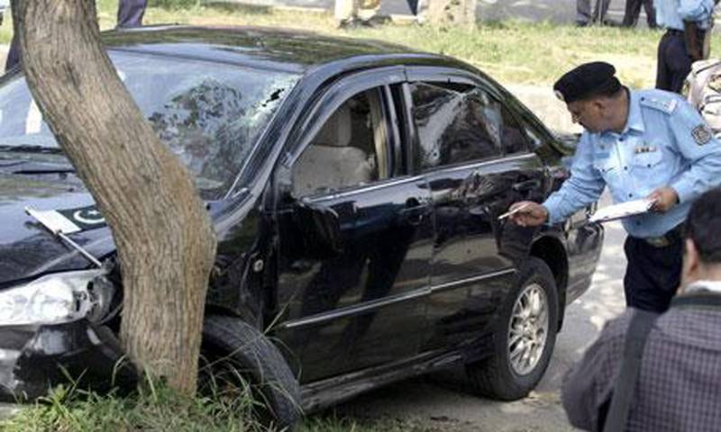 A Pakistani police officer examines a car of Pakistan religious affairs minister Hamid Saeed Kazmi after he was attacked by gunmen in Islamabad, Pakistan, on Wednesday, September 2, 2009.