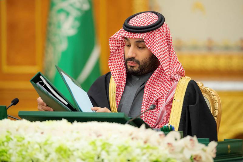 This handout picture provided by the Saudi Royal Palace shows Saudi Crown Prince Mohammed bin Salman signing the state budget during a ministerial council meeting in the capital Riyadh, on December 7, 2022.  Saudi Royal Palace/AFP