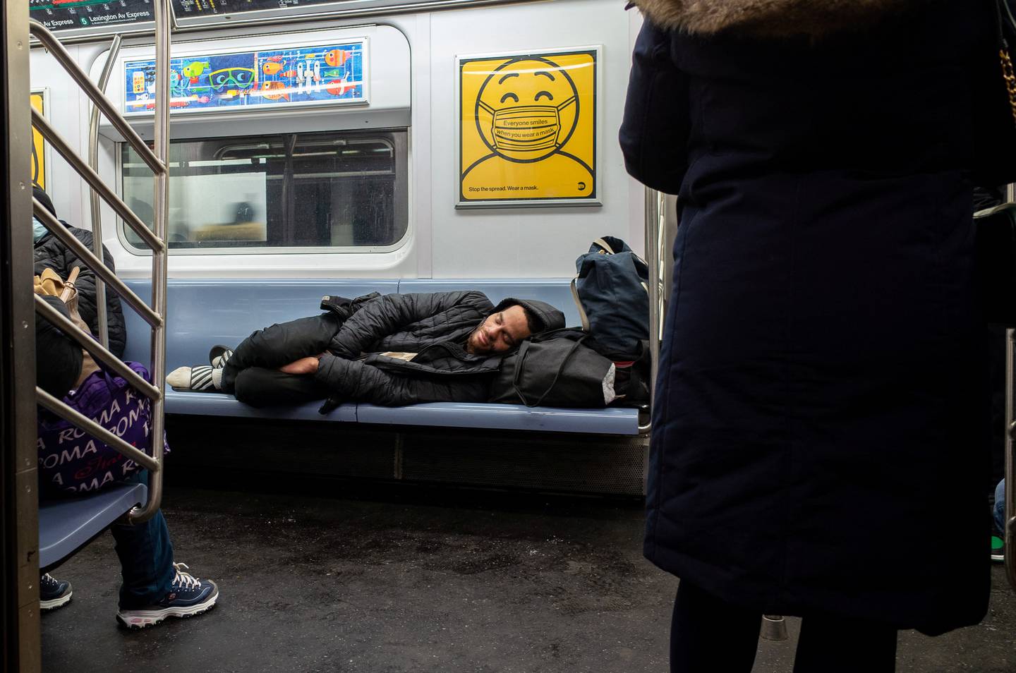 A homeless person sleeps on the subway during rush hour in New York City, February 21. Reuters