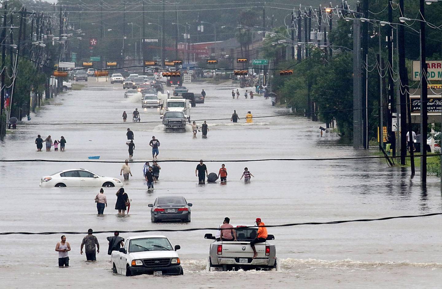 (FILES) This file photo taken on August 27, 2017 shows people walking through the flooded waters of Telephone Rd. in Houston battled with tropical storm Harvey and resulting floods.
Fierce hurricanes, heat waves, floods and wildfires ravaged the planet in 2017, as scientists said the role of climate change in causing or worsening certain natural disasters has grown increasingly clear. It was also the year the world's second largest polluter, the United States, turned its back on the 196-nation Paris climate deal meant to limit global warming to under two degrees Celsius (1.5 degrees Fahrenheit) over pre-industrial levels.
 / AFP PHOTO / Thomas B. Shea / With AFP Story by Kerry SHERDAN: Hurricanes, heat waves, fires ravaged planet in 2017