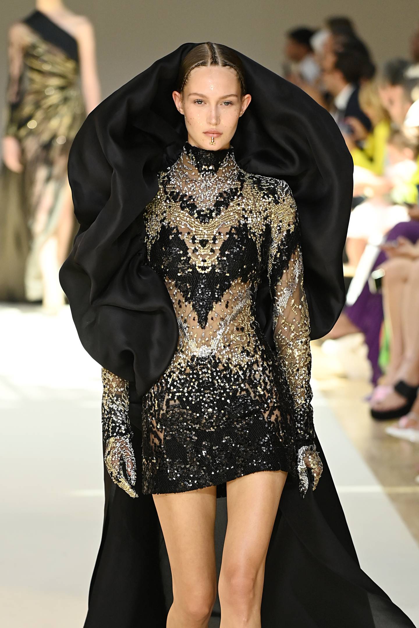 The Elie Saab haute couture autumn/winter 2022-23 show delivered a new softness over Saab's trademark handwork, seen here as a cowled hood, over a decorated mini dress. Getty Images