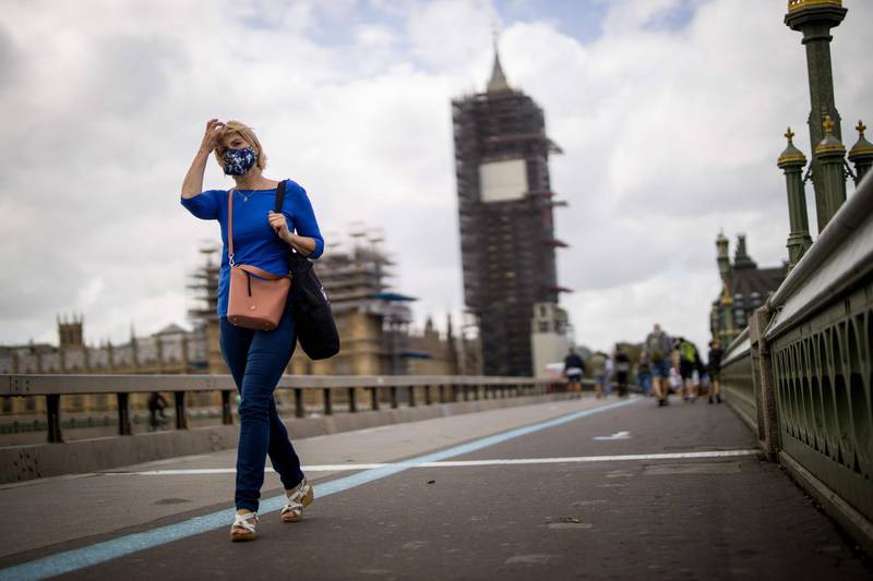 A woman wearing a face mask walks on the Westminster Bridge in central London amid the coronavirus pandemic.  AFP