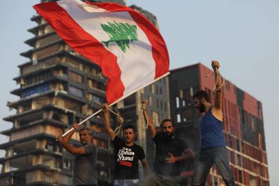 Protesters wave a Lebanese flag and hold nooses, which have become symbols of public anger against the Lebanese government, as they commemorate a month since the city's deadly explosion. Getty Images