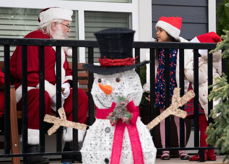 Santa stays physically distanced as he visits Serena and Ariana Eslami at their home in Abbotsford, British Columbia, Canada, December 6. AP