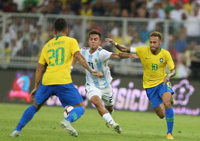 Brazil's Neymar and Roberto Firmino and Argentina forward Paulo Dybala tussle for the ball. AFP