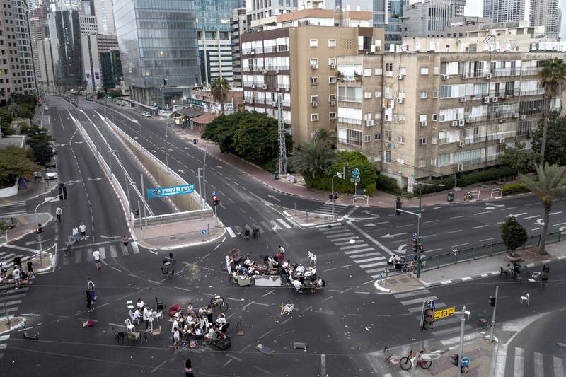 A group of youths sits at a junction on a car-free road in Ramat Gan, Israel, marking the Jewish holiday of Yom Kippur, during which no traffic is permitted on the roads. AP
