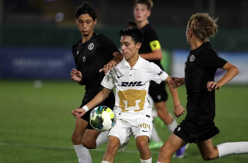 Players in action during the U14 Mina Cup final match between Pumas (white) and City Football Club.
