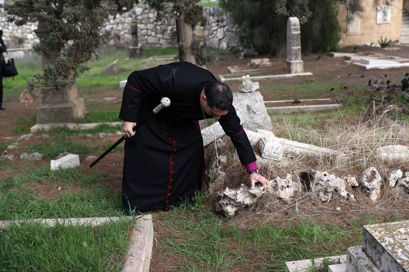 Bishop Hosam Naoum inspects vandalised graves at a Protestant cemetery on Mount Zion, Jerusalem. EPA