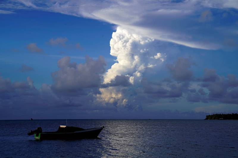 This file photo taken on December 21, 2021 shows white gaseous clouds rising from an eruption of the Hunga Tonga-Hunga Ha’apai volcano from the Patangata coastline, near the Tongan capital, Nuku’alofa.  Frightened Tongans fled to higher ground after the latest eruption of the volcano, heard in neighbouring countries, triggered tsunami warnings in the South Pacific. AFP