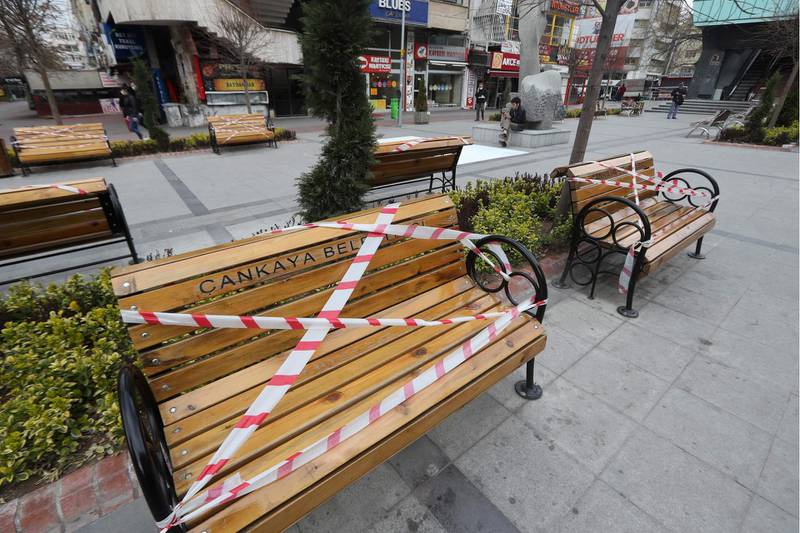Benches stand with tape placed by authorities, to prevent them being used, on a pavement of Sakarya Street in Ankara.  AFP