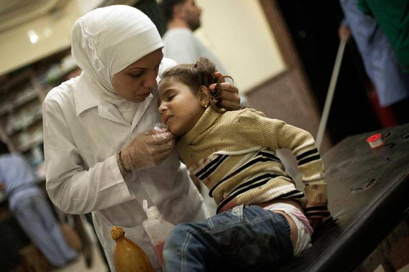 The caring hands of a Syrian nurse at Dar Al Shifa hospital treats a girl wounded by Syrian Army artillery shelling.
