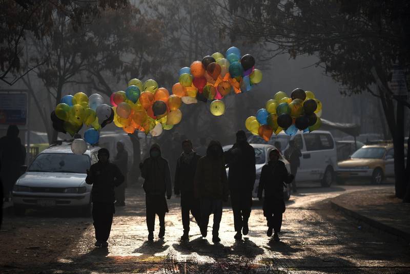 Afghan balloon vendors walks past the Ministry of Public Works a day after a deadly militant attack in Kabul on December 25, 2018. An hours-long gun and suicide attack on a Kabul government compound killed at least 43 people, the health ministry said December 25, making it one of the deadliest assaults on the Afghan capital this year.
 / AFP / WAKIL KOHSAR
