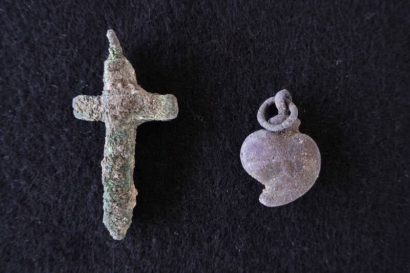 A crucifix and Christian 'sacred heart' pendant found in Portuguese graves at Stone Town. Photo: Tim Power