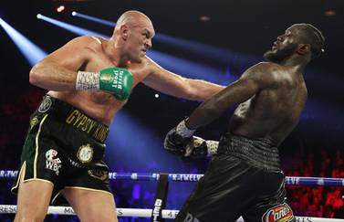 (FILES) In this file photo Tyson Fury punches Deontay Wilder during their Heavyweight bout for Wilder's WBC and Fury's lineal heavyweight title on February 22, 2020 at MGM Grand Garden Arena in Las Vegas, Nevada. Tyson Fury's heavyweight unification fight with Anthony Joshua could be put on hold after an independent arbitrator ruled that the WBC heavyweight champion must face former champion Deontay Wilder in a rematch, US reports said May 17, 2021. / AFP / GETTY IMAGES NORTH AMERICA / AL BELLO