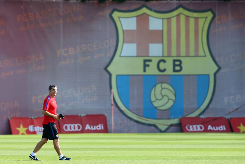 Football Soccer - Barcelona training session - Joan Gamper training camp, Barcelona, Spain - July 17, 2017 - Barcelona's coach Ernesto Valverde walks past a giant logo of the team during a training session. REUTERS/Albert Gea