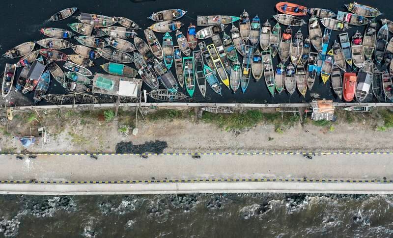 Boats at a dock behind the coastal embankment in Cilincing, Jakarta