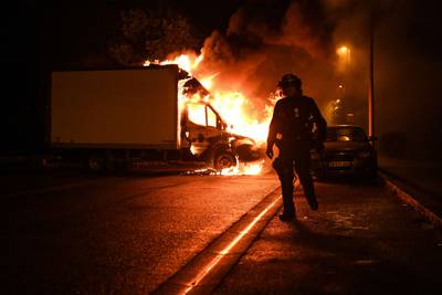 A policemen walks past a burning lorry in Nantes, western France, amid protests. AFP