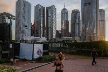 A jogger runs as buildings stand in the Central district in Hong Kong, China, on Monday, June 22, 2020. Bloomberg