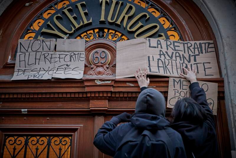 High school students put up placards that read "Retirement before Arthritis" in Paris during the nationwide strike on Thursday. Getty Images