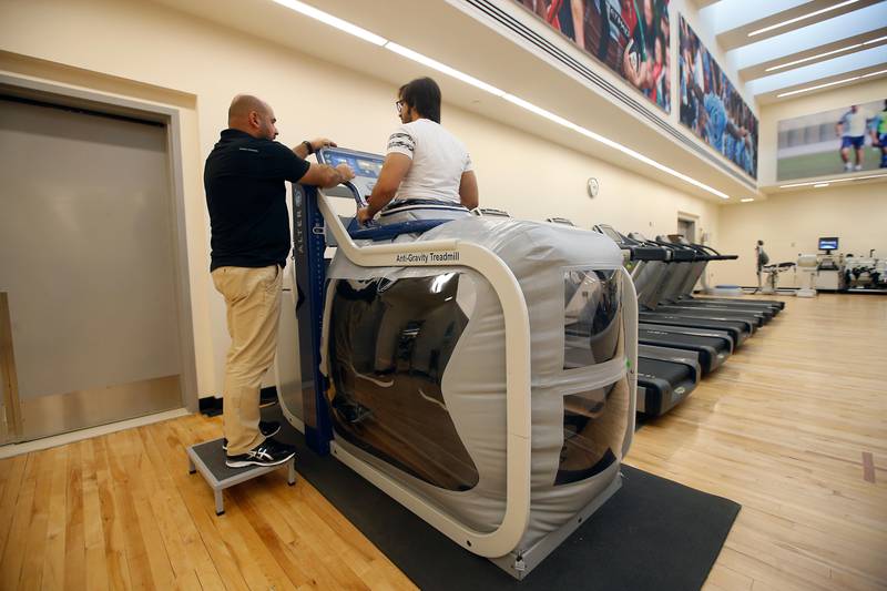 ABU DHABI - UNITED ARAB EMIRATES - 25OCT2016 - Azzam Kamal (in black t-shirt) Head of physiotherapy department, monitors Hamdan Jumei al Hindaassi, a patience working on anti-gravity treadmill which uses a sort of blow up tent to take weight off a patient while they're on the treadmill. It means the rehabilitation process can be better personalised and hopefully lead to a quicker recovery Healthpoint hospital in Abu Dhabi. Ravindranath K / The National (to go with Mitya Underwood story for Healthy Living magazine) ID: 20438 *** Local Caption ***  RK2410-antigravitytreadmill08.jpg