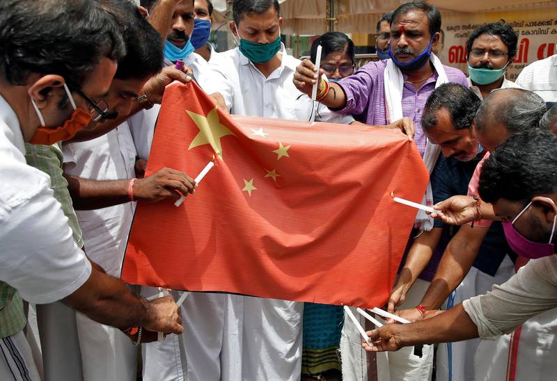 Supporters of India's ruling Bharatiya Jayanta Party (BJP) attempt to burn a sheet resembling the Chinese national flag during a protest against China, in Kochi, India. REUTERS