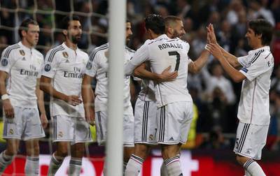 Real Madrid's Karim Benzema celebrates with Cristiano Ronaldo and other teammates after scoring his team's third goal against Schalke in the Champions League on Tuesday. Juan Medina / Reuters
