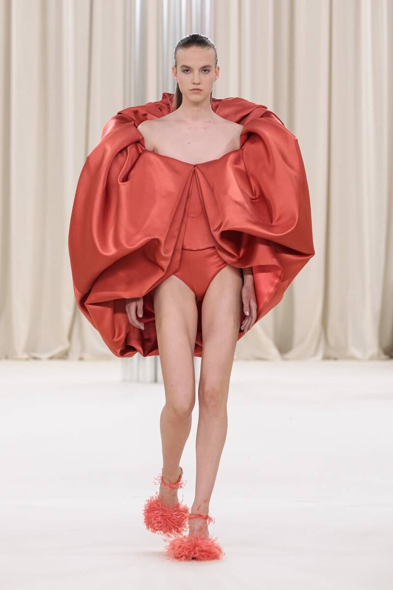 A dress was a round of red satin that opens to reveal a matching bodysuit. 