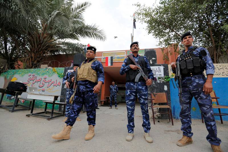 Iraqi security forces stand guard outside a polling station during the parliamentary election in the Sadr city district of Baghdad. Wissm al-Okili / Reuters