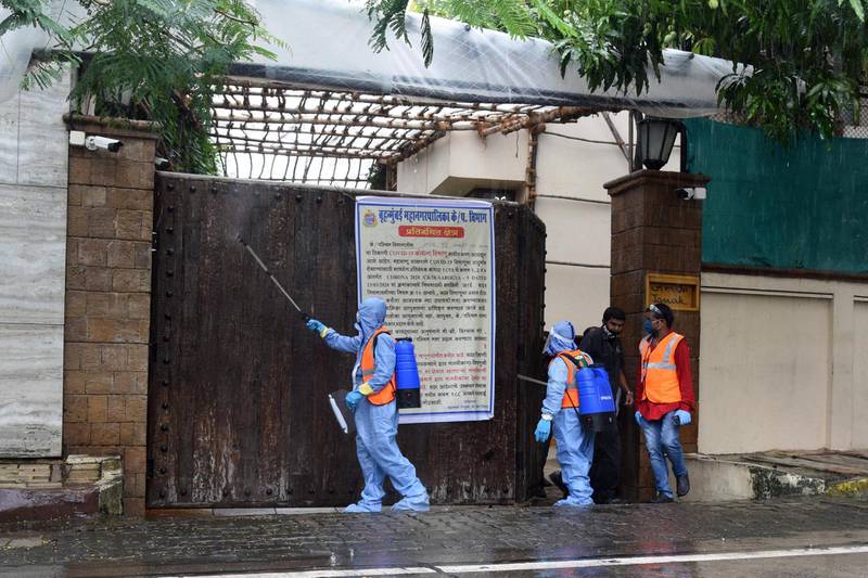 Civic authority workers spray sanitiser on the main door of the residence of Bollywood star Amitabh Bachchan as he tested positive for COVID-19 in Mumbai on July 12, 2020. Bollywood megastar Amitabh Bachchan, 77, tested positive for COVID-19 on July 11 and was admitted to hospital in Mumbai, with his actor son Abhishek -- who also announced he had the virus -- saying both cases were mild. / AFP / Sujit Jaiswal
