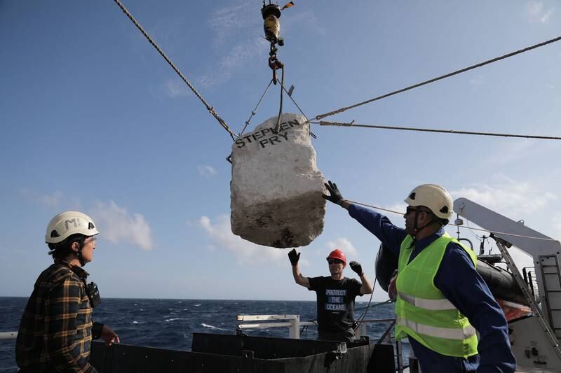 A team on the Greenpeace ship 'Arctic Sunrise' prepare to place a boulder in the sea. Photo: Greenpeace