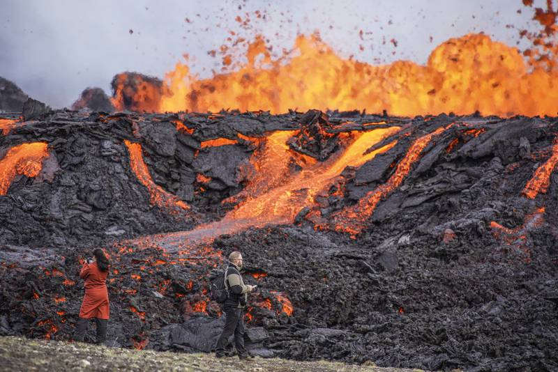 People look at the lava flowing on Fagradalsfjall volcano in Iceland, which is 32 kilometres south-west of the capital Reykjavik. AP Photo
