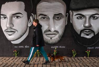 A man passes in front of a mural with portraits of victims of the 2020 Hanau shootings under a bridge in Frankfurt am Main, western Germany. AFP
