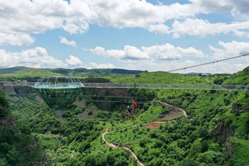 Performers ride bikes on a zip line next to the 240-metre-long glass bridge. 