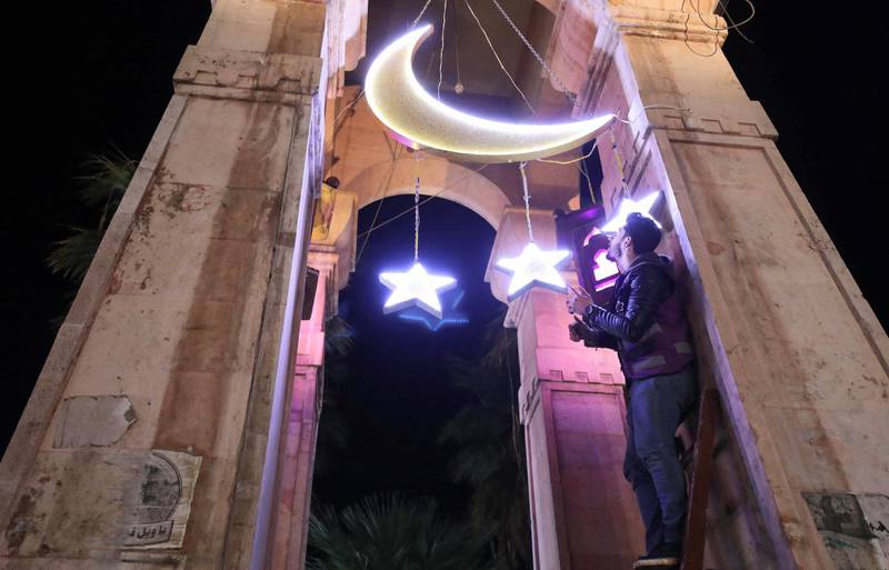 A Syrian man adjusts decorations for the Muslim holy fasting month of Ramadan at the Clock Square in Syria's rebel-held northwestern city of Idlib. AFP
