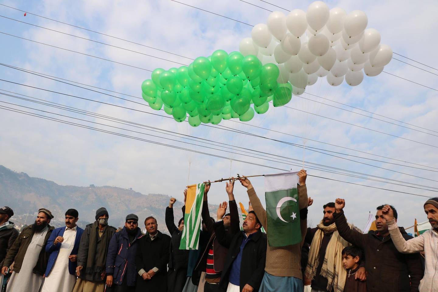 epa08988771 Kashmiris hold Pakistani and Pakistan administered Kashmir's flags during protest to show solidarity with Kashmiris living in the Indian administered part, on Kashmir Solidarity Day, in Muzaffarabad, the capital of Pakistani administered Kashmir, 05 February 2021. Demonstrators demanded an end to Indian rule in the region and a settlement of the dispute according to wishes of Kashmiris and UN resolutions. Kashmir, a Muslim majority Himalayan territory divided between the two nuclear armed neighbors, has triggered two wars between them since their independence from Britain in 1947.  EPA/AMIRUDDIN MUGHAL