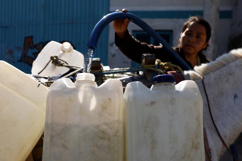 Resident Lourdes Martinez fills water tanks with water for her family daily use as Mexico City and the metropolitan area is running out of water as drought takes hold of the city of almost 22 million people in the municipality of Xochimilco in Mexico City, Mexico. Reuters