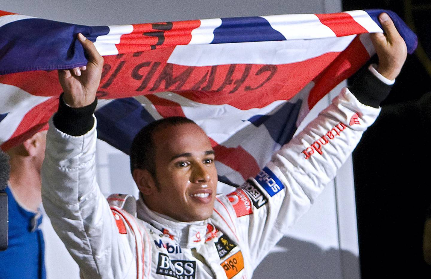 British Formula One driver Lewis Hamilton waves his national flag to celebrate after winning the F-1 World Championship on November 2, 2008, at Interlagos race track in Sao Paulo, Brazil. Hamilton was crowned Formula One champion after finishing fifth in the Brazil Grand Prix.   AFP PHOTO / ANTONIO SCORZA (Photo by ANTONIO SCORZA / AFP)