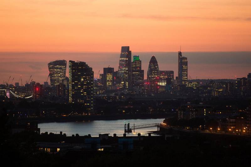 Lights illuminate skyscrapers as the sun sets in the City of London, U.K. Photographer: Simon Dawson/Bloomberg