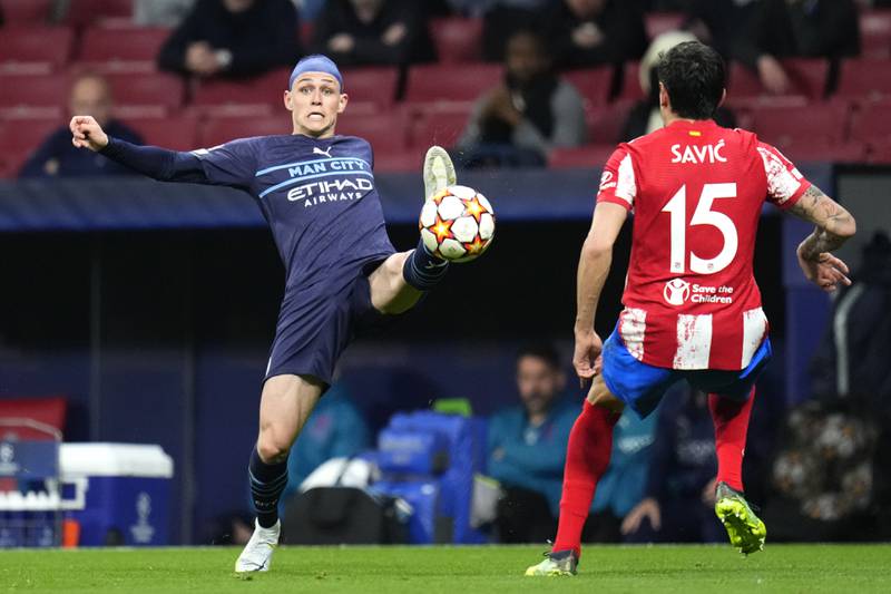 Atletico Madrid's Stefan Savic, right, watches as Manchester City's Phil Foden reaches for the ball. AP