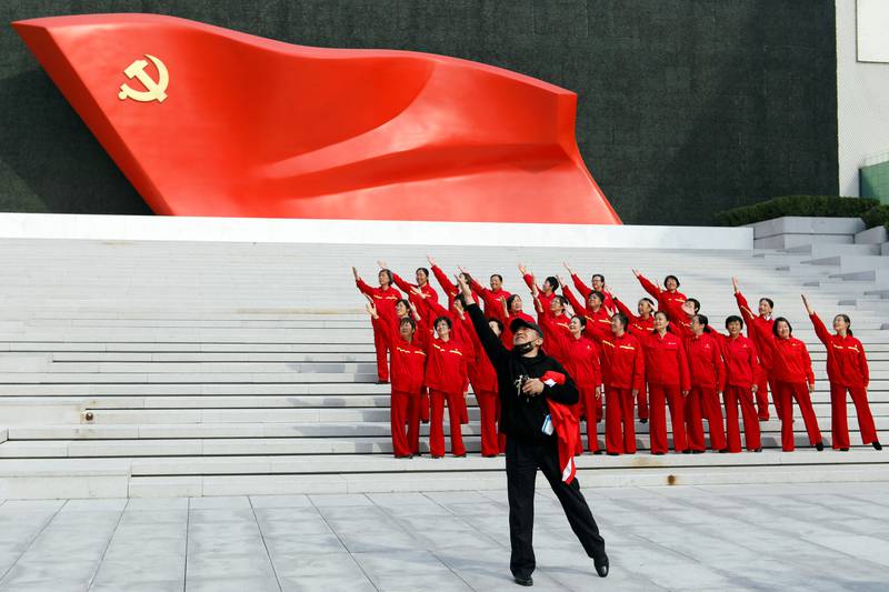Visitors pose for a video in front of an installation of the Chinese Communist Party flag in Beijing. Reuters