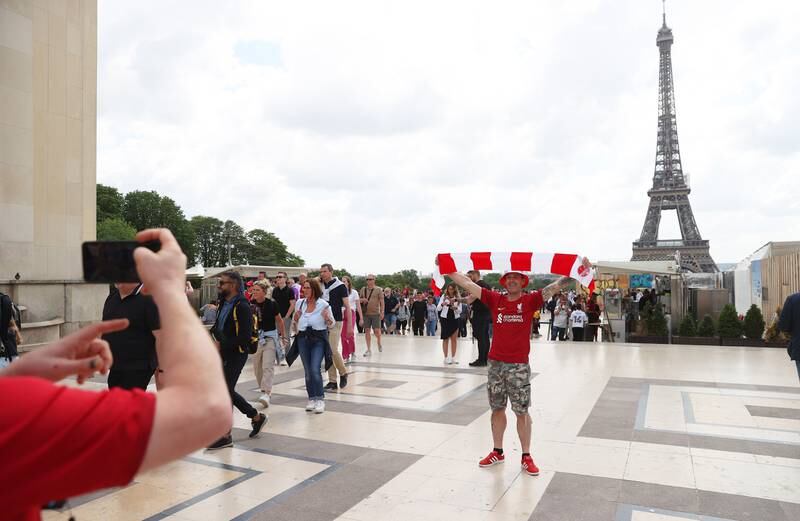 A Liverpool fan poses for a photograph in front of the Eiffel Tower. Getty