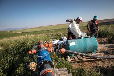 Farmers Cafer Ungor, left, and Ferhat Altintas add fertiliser to water extracted from their groundwater well. Two years of extreme drought has forced farmers to tap in to underground sources to sustain their crops.