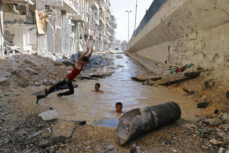 A boy dives into a crater filled with water in Aleppo’s al-Shaar district. Activists said the crater was caused by barrel bombs dropped by forces of Syria’s President Bashar al-Assad. Hosam Katan / Reuters