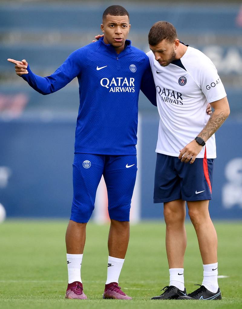 PSG forward Kylian Mbappe with member of the coaching staff. AFP