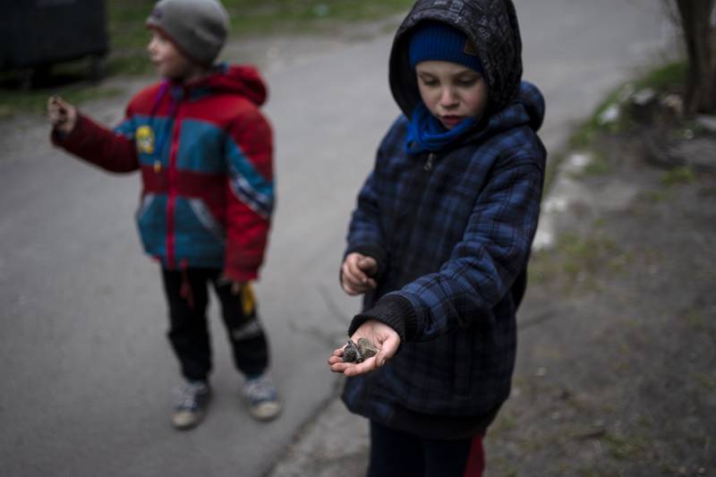A boy shows the shell of a bullet in Bucha. AP