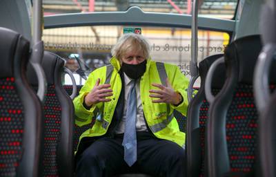 COVENTRY, ENGLAND - MARCH 15: Prime Minister Boris Johnson sits on the back of a bus during a visit to the National Express depot in Coventry on March 15, 2021 in Coventry, England. The Prime Minister is unveiling a shake-up of the bus sector which aims to see lower, simpler flat fares in towns and cities, turn-up-and-go services on main routes, and new flexible services to reconnect communities. (Photo by Steve Parsons-WPA Pool/Getty Images)