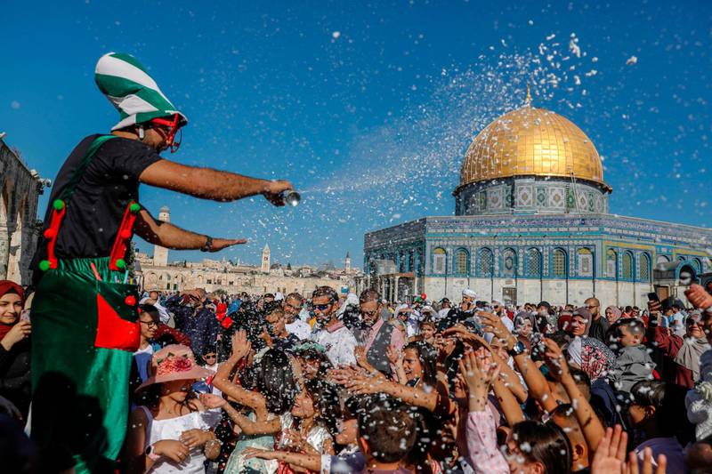 A clown entertains Palestinians on the first day of Eid Al Adha near the Dome of Rock mosque at the Al-Aqsa Mosque compound, Islam's third most holy site, in the Old City of Jerusalem.  AFP