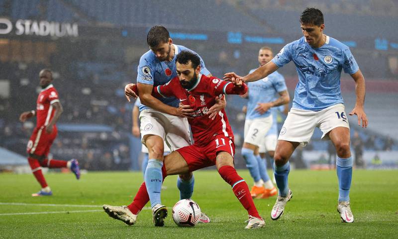 Liverpool's Mohamed Salah surrounded by Ruben Dias, left, and Rodri of City. PA